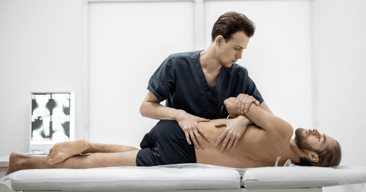 Physical therapist performing manual treatment on a patient's hip and lower back area to alleviate sciatica symptoms.